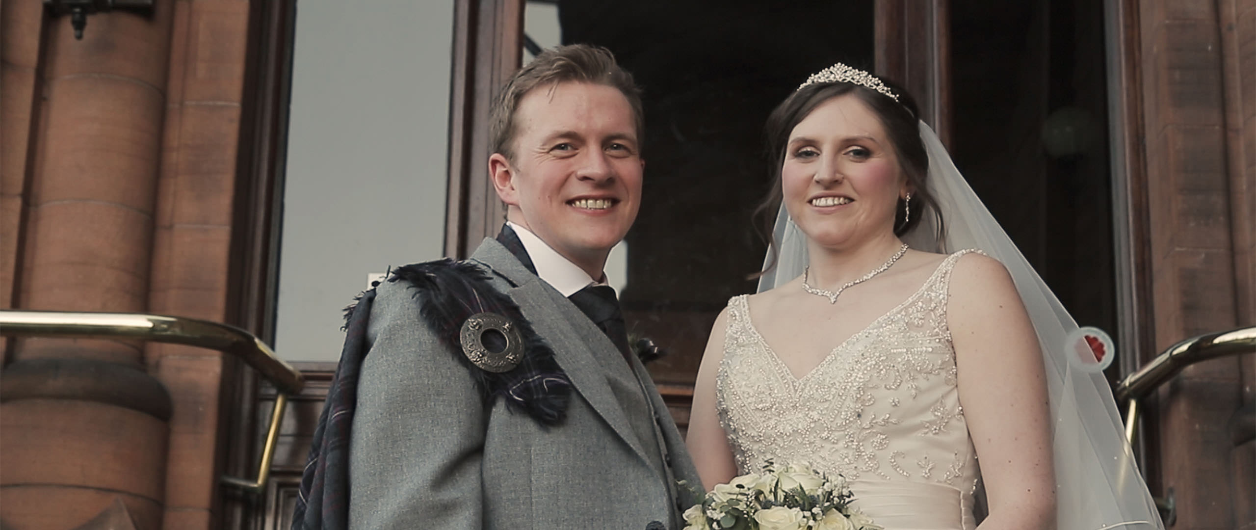 Sherbrooke Castle Hotel - Glasgow wedding videographers Wedding couple standing on the stairs to the Sherbrooke Castle Hotel in Glasgow